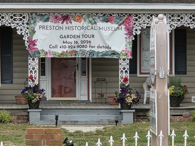 A banner for the Preston Historical Museum Garden Tour hangs on the porch of the museum in Preston, Maryland.
